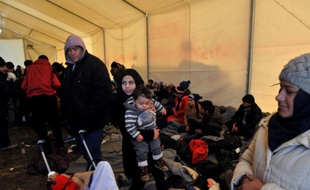 Des migrants et réfugiés, bloqués à Idomeni, à la frontière gréco-macédonienne, se réchauffent sous une tente, le 21 janvier 2016