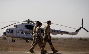 Des soldats français passent devant un hélicoptère de l'ONU stationné sur la base militaire française à Gao, le 31 décembre 2013