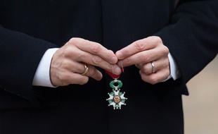 Une Légion d'honneur dans les mains d'Emmanuel Macron.