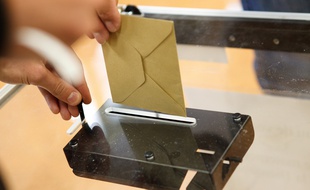 Enveloppe mise dans une urne.