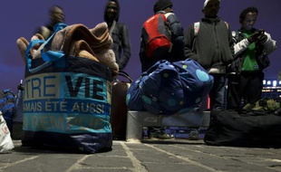 Des migrants ramassent leurs affaires, se préparant à quitter leur camp de fortune près de la gare d'Austerlitz à Paris, le 17 septembre 2015