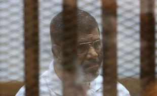Le président islamiste Mohamed Morsi destitué par l'armée, derrière les grillages du banc des accusés lors de son procès au Caire le 18 août 2014
