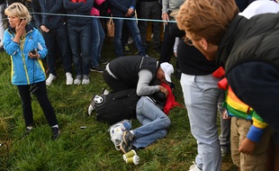 Une spectatrice de la Ryder Cup allongée au sol, touchée au visage par une balle de golf.