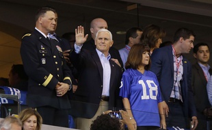Mike Pence salue les supporters lors d'un match de football américain, avant de quitter le stade quelques instants plus tard.