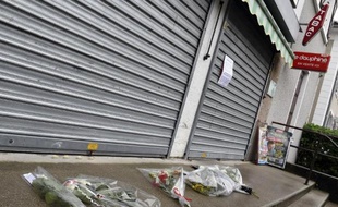 Des fleurs sont déposés devant le tabac où un homme a été tué à Dolomieu le 30 juillet 2014