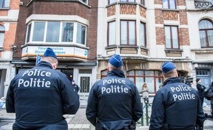 Trois officiers de police belges montent la garde dans la commune de Schaerbeek, dans la région de Bruxelles, le 25 mars 2016