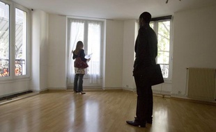 Jeune femme visitant un appartement avec un agent immobilier.
