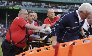 Des soigneurs des Boston Red Sox soignent une femme blessée par un morceau de batte de baseball, à Boston le 6 juin 2015.