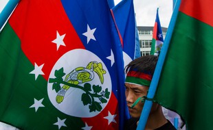 Un homme manifeste, un drapeau Chin à la main, contre le conflit qui secoue sa région, le 13 juillet 2019 à Rangoun.