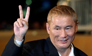 Le réalisateur Takeshi Kitano fait le «V» de la victoire à la Mostra de Venise, le 2 septembre 2003.