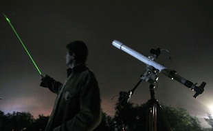 Un homme pointe un laser vers le ciel. illustration