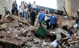 Des hommes cherchent des survivants dans les décombres d'une usine d'Alexandrie (Egypte) qui s'est effondrée le 12 décembre 2010.