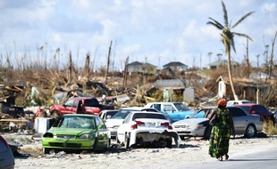 Un femme marche à côté des décombres, après le passage de l'ouragan Dorian à Marsh Harbour.