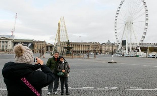 Des touristes prennent la pose devant la place de la Concorde à Paris le 30 novembre 2015