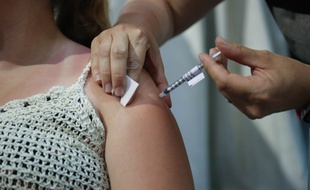 Illustration d'une jeune femme se faisant vacciner.