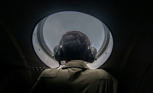 TOPSHOTS
A member of the Indonesian military looks out of the window during a search and rescue (SAR) operation for missing Malaysian air carrier AirAsia flight QZ8501, over the waters of the Java Sea on December 29, 2014. Multinational teams searched on December 29 for any sign of the AirAsia plane missing off Indonesia with 162 people on board, but one top official warned it was likely at the bottom of the sea. AFP PHOTO / Juni KRISWANTO