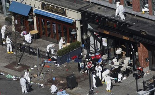 Des enquêteurs examinent la scène du double attentat de Boston qui a fait 3 morts et 176 blessés le 15 avril 2013.
