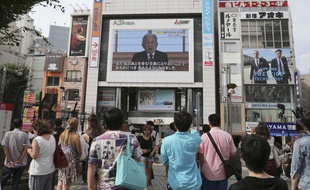 Des Japonais regardent le discours de l'empereur Akihito à Tokyo, le 8 août 2016.