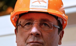 (FILES) -- This file photo taken on September 26, 2013 in Florange, eastern France, shows French President Francois Hollande (L) visiting the ArcelorMittal steel factory. Hollande is to visit again the Florange plant site on November 24, 2014, which fate has become a litmus test of Hollande's strategy for fighting rising unemployment and raising the flagging competitiveness of French industry. AFP PHOTO / PATRICK HERTZOG