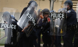 Des policiers de Baltimore essuient des jets de projectiles devant un centre commercial après les funérailles de Freddie Gray, jeune Noir tué par un policier blanc, le 27 avril 2015.