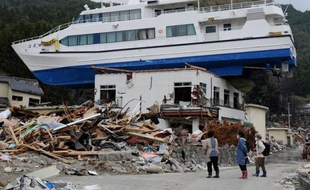 Le bateau hissé sur un bâtiment de deux étages par le tsunami a disparu et la plupart des débris qui jonchaient le port de pêche d'Otsuchi ont été déblayés, mais une question se pose un an après: faut-il reconstruire une ville à l'avenir aussi incertain ?