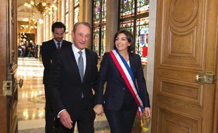 La nouvelle maire de Paris Anne Hidalgo portant son écharpe tricolore, escorte son prédécesseur socialiste Bertrand Delanoë qui quitte l'hôtel de ville après la session inaugurale du conseil de Paris, le 5 avril 2014