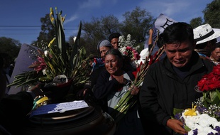 Des Boliviens pleurent la disparition de leurs proches.