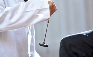 Photo d'illustration: un médecin teste les réflexes d'un patient lors d'une consultation.