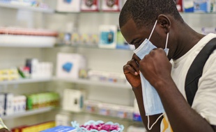 Un homme essaie un masque facial censé protéger du coronavirus.