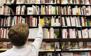 Un employé range des livres dans les rayons de la librairie La Procure, le 7 février 2012 à Paris