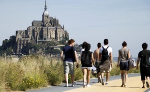 De jeunes touristes marchent vers le Mont-Saint-Michel, le 11 août 2012