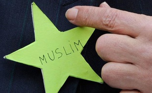 Abderrahmane Dahmane, ancien conseiller technique chargé de l'intégration auprès de Nicolas Sarkozy, pointe du doigt une étoile verte lors d'une conférence de presse à la Grande Mosquée de Paris, le 29 mars 2011. Il appelle les musulmans à faire de même afin de dénoncer le débat sur la laïcité.