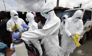 Des membres de la Croix-Rouge se préparent à récupérer le corps d'une victime du virus Ebola, le 4 octobre 2014 dans le quartier de West Point, à Monrovia, au Liberia