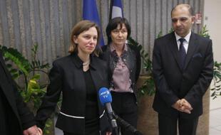 La secrétaire dÉtat au Développement et à la Francophonie Annick Girardin (c), l'ambassadeur de Tunisie en France Mohamed Ali Chihi et Emilie Belloche (g), la fille de Christophe Tinois, victime de l'attentat du musée du Bardo, le 26 mars 2015 à l'aéroport de Roissy à Paris