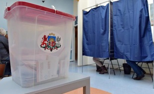 Une urne devant les isoloirs d'un bureau de vote de Riga, le 4 octobre 2014
