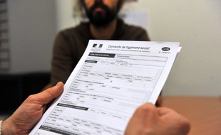 Une personne tient un document de demande de logement social dans un bureau d'aide sociale, le 30 Janvier 2012 à Tours.