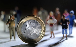Une pièce d'un euro devant des figurines.