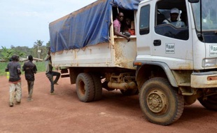 Des travailleurs de la plantation d'hévéas, qui appartient au géant singapourien Olam, montent dans un camion à la fin de leur journée à Batouri, dans le nord du Gabon, le 30 avril 2015
