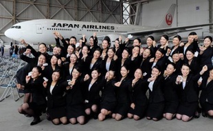 Les nouvelles hôtesses recrutées par Japan Airlines posent devant un Boeing 777 à Tokyo le 1er avril 2015, au cours de la cérémonie qui marque le début de carrière de 1.067 nouvelles recrues pour les 30 entreprises du groupe JAL