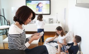 Illustration: télévision et smartphone dans un foyer français.