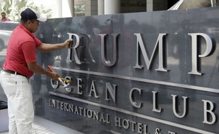 Un ouvrier ôte une à une les lettres formant «Trump» à l'entrée du Trump Hotel de Panama City, le 5 mars 2018.