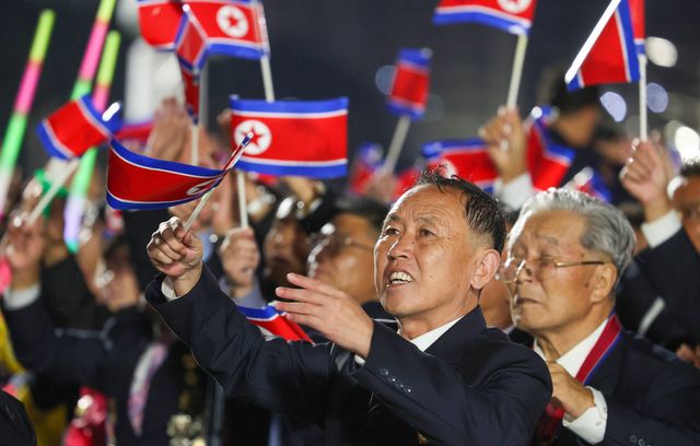 Des milliers de Nord-Coréens ont assisté au défilé, drapeau de leur pays fièrement en main.