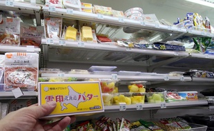 Un client tient une plaquette de beurre dans un magasin de Tokyo, le 10 novembre 2014.