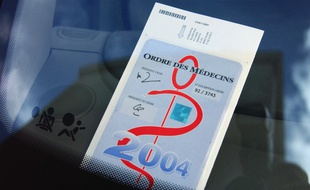 Un caducée sur le pare-brise d'une voiture en stationnement