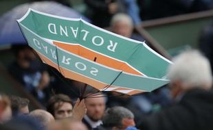 A spectator's umbrella is upside down as rain delays the play between France's Kristina Mladenovic and Timea Bacsinszky of Switzerland during their quarterfinal match of the French Open tennis tournament at the Roland Garros stadium, Tuesday, June 6, 2017 in Paris.