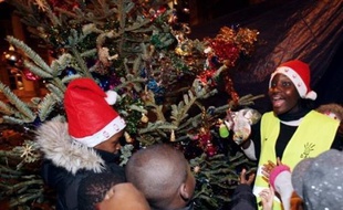 Mal-logés et sympathisants de l'association Droit au Logement (Dal) ont organisé mercredi soir un Noël de fortune pour les enfants, au pied du campement de tentes et de bâches rue de la Banque dans le centre de Paris.