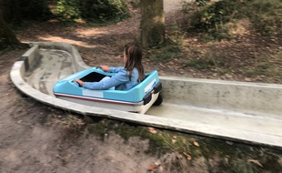 Une petite fille dévale la piste du Babybob du parc de Procé.
