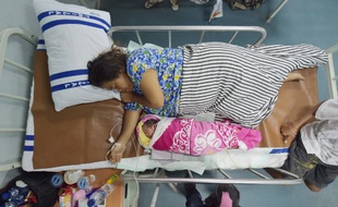 Dinar, Indonésienne de 38 ans, se repose au côté de son nouvea-né, dont elle a accouché à bord du bateau-hôpital "KRI Dian Suharsi", à Pantoloan, le 6 octobre 2018.