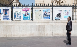 Un homme devant les affiches des élections municipales à Marseille.