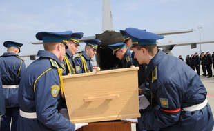 Des soldats ukrainiens soulèvent le cercueil contenant les restes de l'une des victimes du crash du vol MH17 de la Malaysia Airlines, le 28 mars 2015.